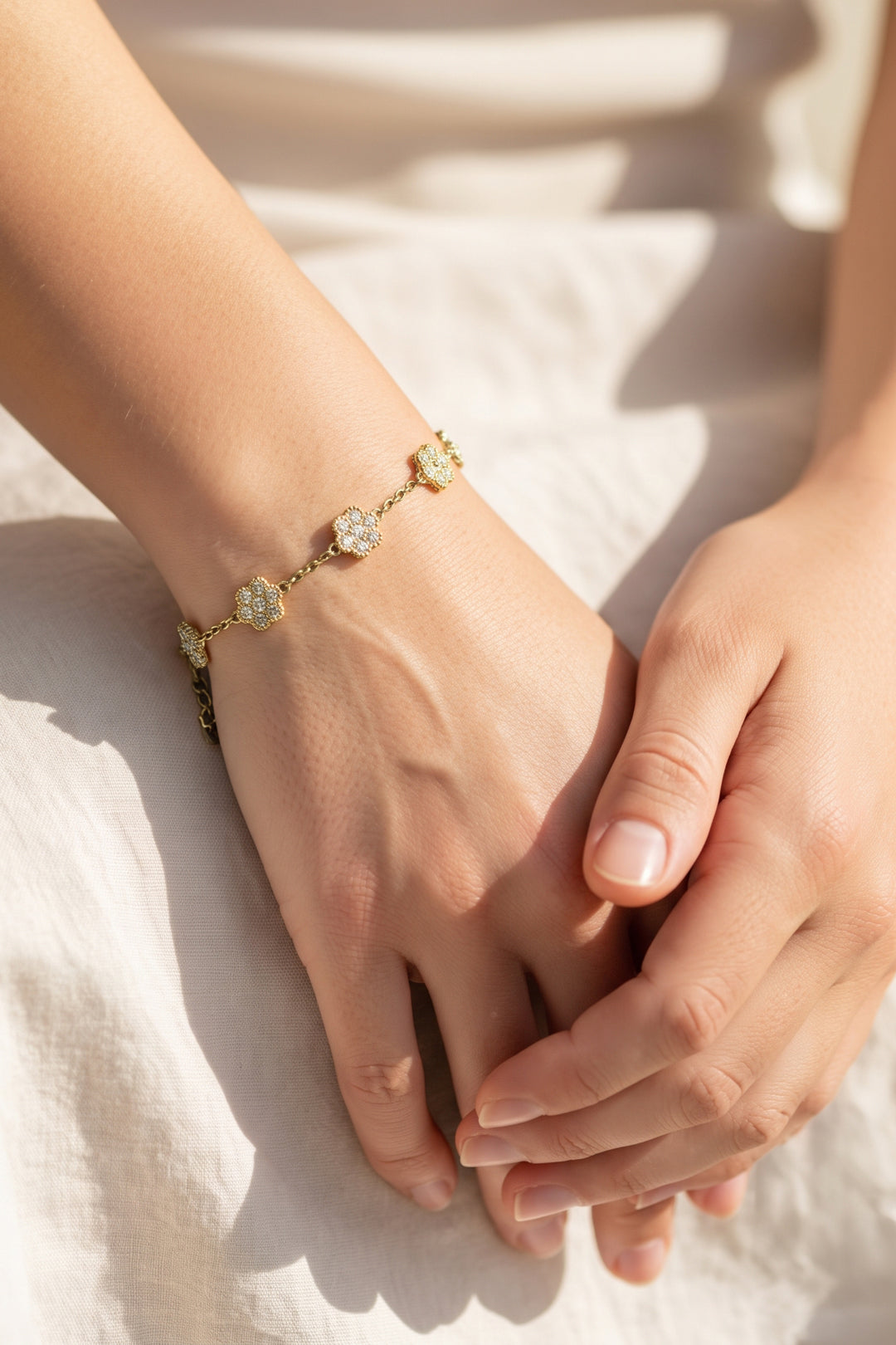 Goldfarbenes Armband am Handgelenk mit runden Glitzersteinen auf Gliederkette