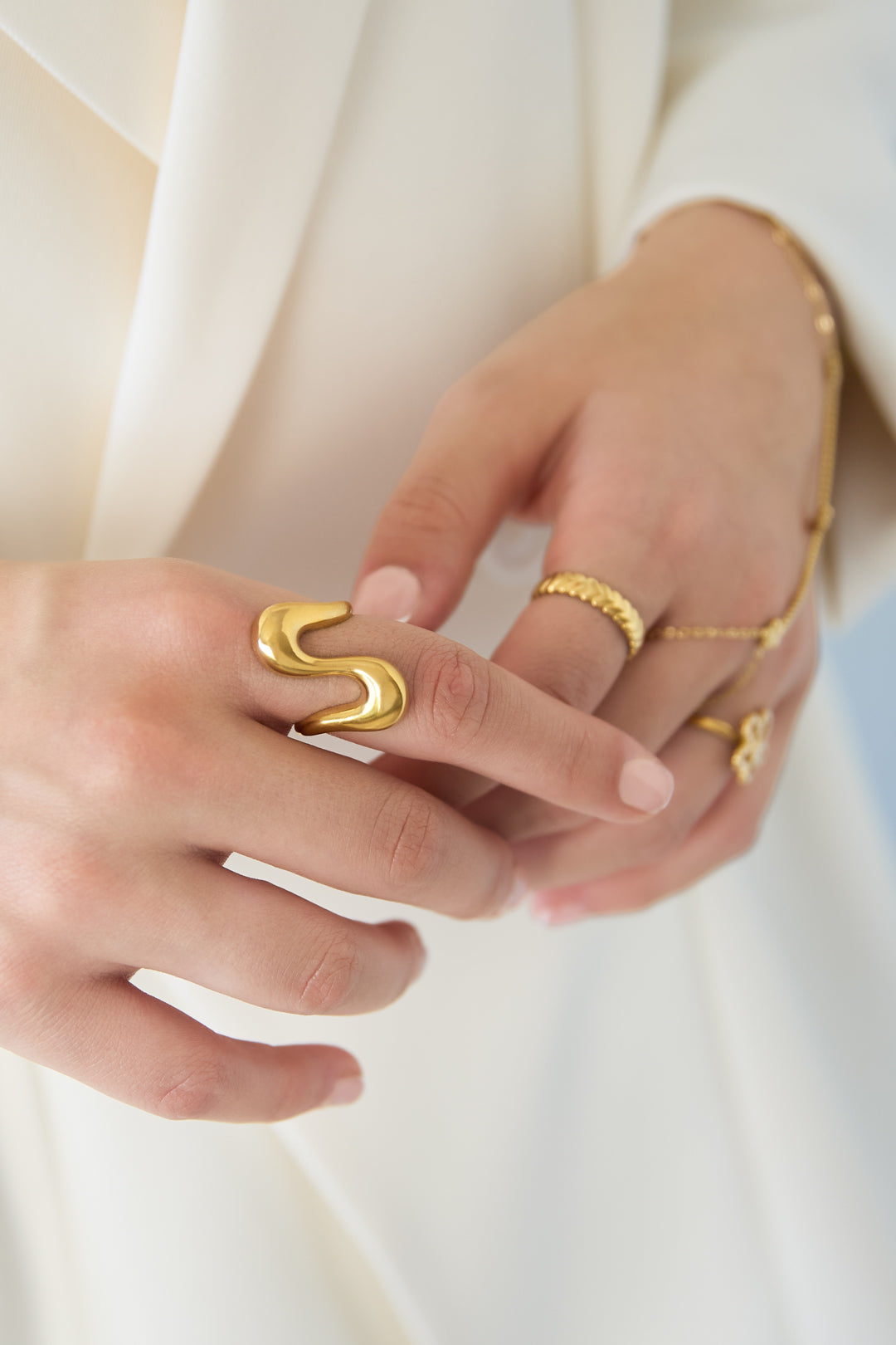 Goldfarbener Ring mit herzförmiger Öse am Finger