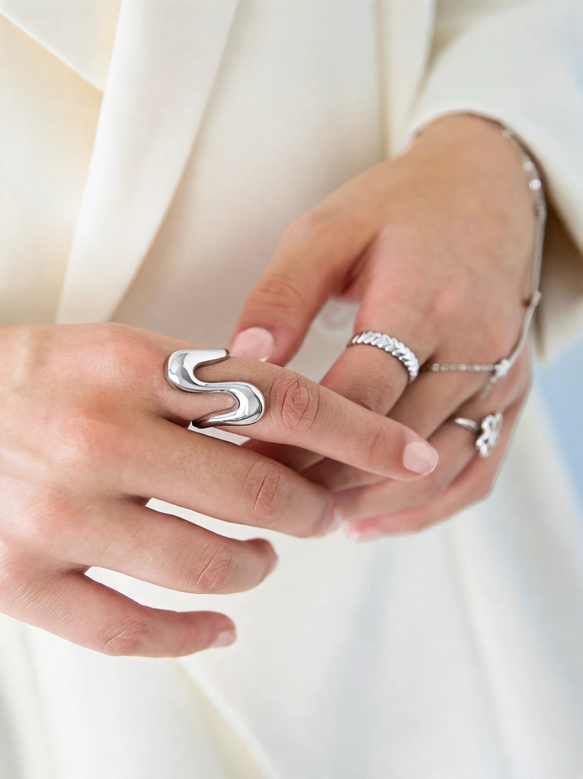 Silberfarbener Ring am Finger mit herzförmiger Öffnung