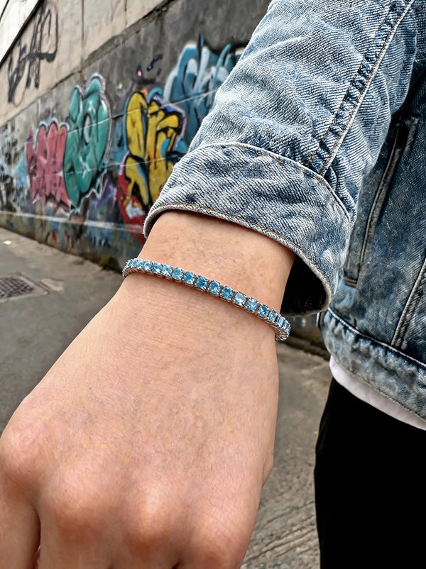 Tennisarmband am Handgelenk mit blauen Zirkonia-Steinen im schmalen Silberband